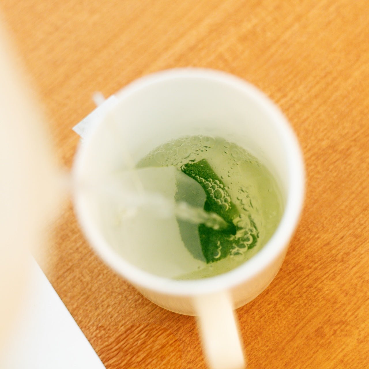 マグカップの霧島茶ティーバッグにお湯を注ぐ様子(真上から) / Pouring hot water over a Kirishima tea bag in a mug - 今村茶園